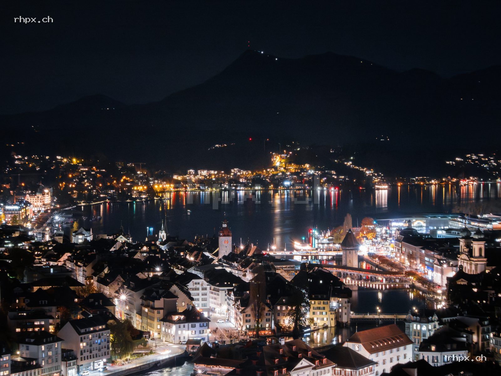 Nächtlicher Blick über Luzern mit Vierwaldstättersee, Stadtlichtern, Kapellbrücke, Wasserturm und Rigi im Hintergrund