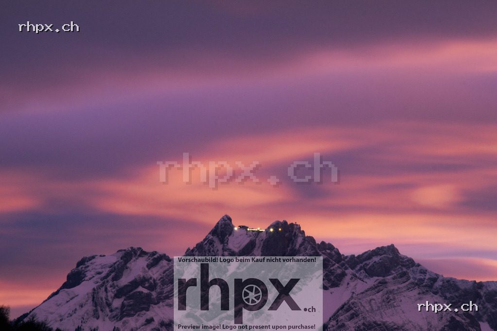 Snow-covered Mount Pilatus with summit buildings at sunset, sky in shades of pink and violet