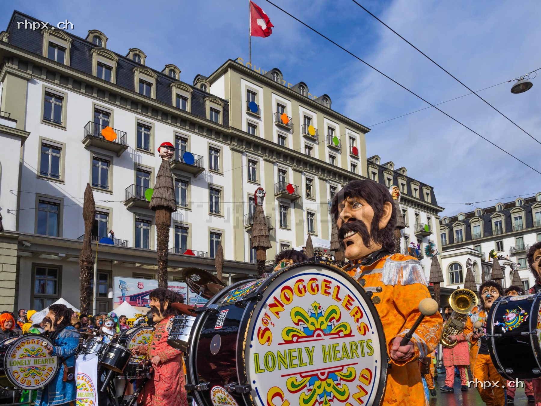 Members of a carnival band in Lucerne with brass instruments, drums, masks and colourful costumes.