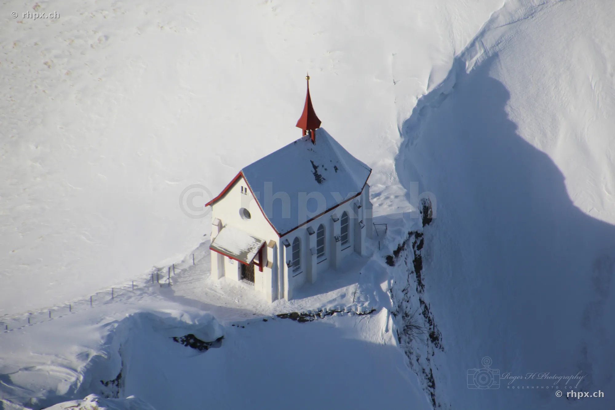 Aerial view of the snow-covered mountain chapel on Mount Pilatus