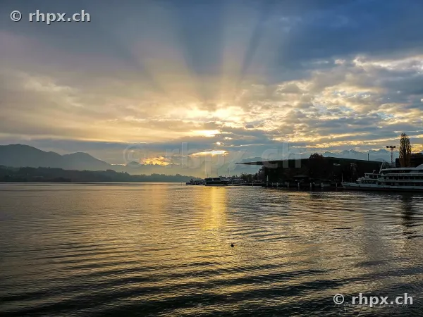 Sonnenstrahlen über dem Vierwaldstättersee bei Luzern mit Schifflände
