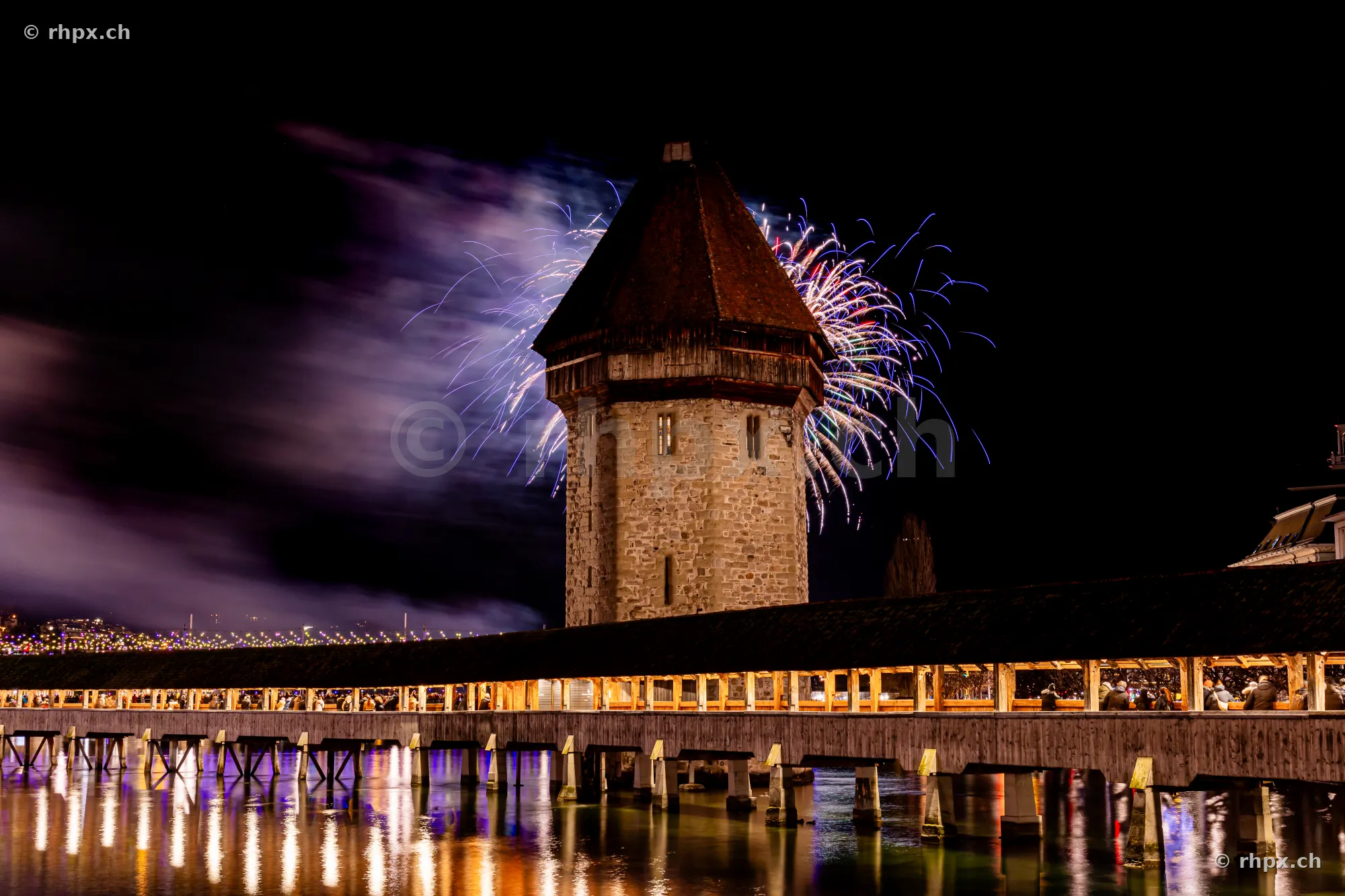 Chapel Bridge in Lucerne at night with fireworks on New Year's Eve 2024