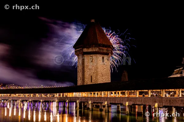 Chapel Bridge in Lucerne at night with fireworks on New Year's Eve 2024
