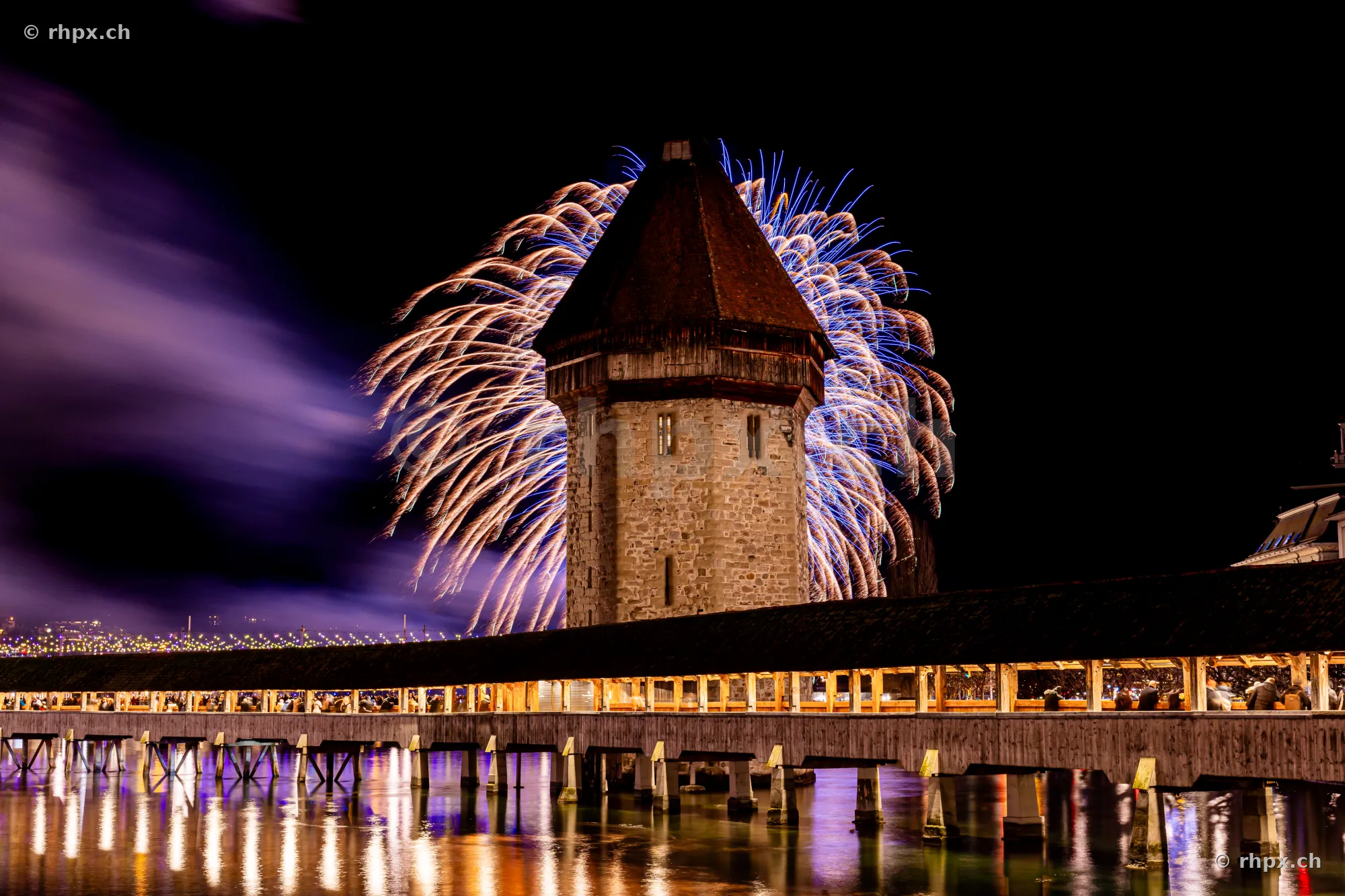 New Year fireworks behind the water tower of the Chapel Bridge in Lucerne at night