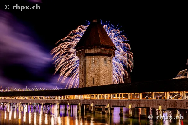 Neujahrsfeuerwerk hinter dem Wasserturm der Kapellbrücke in Luzern bei Nacht