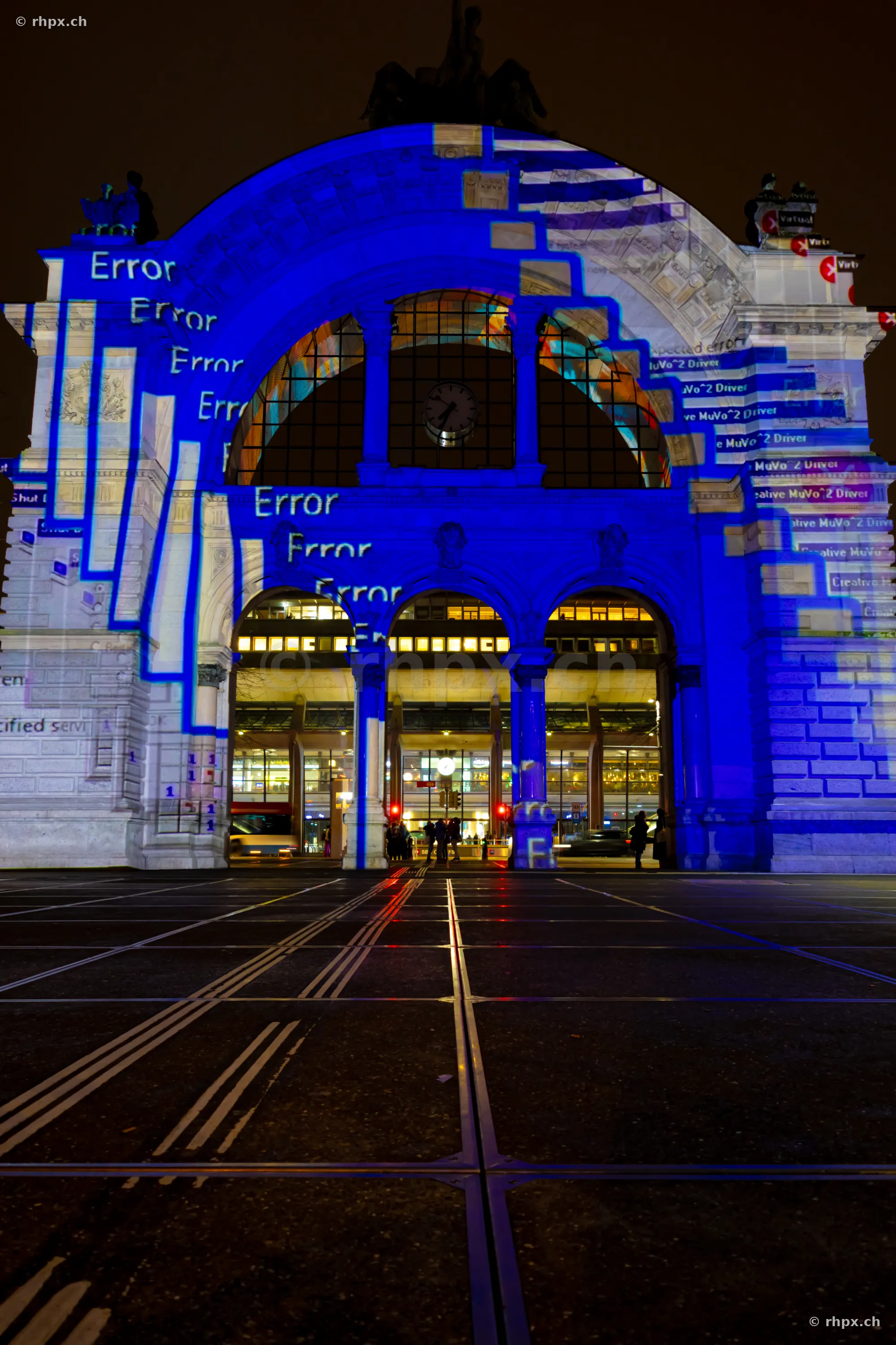 Blaue Lichtprojektion mit Schriftzug Error an der Fassade des Bahnhofs Luzern.