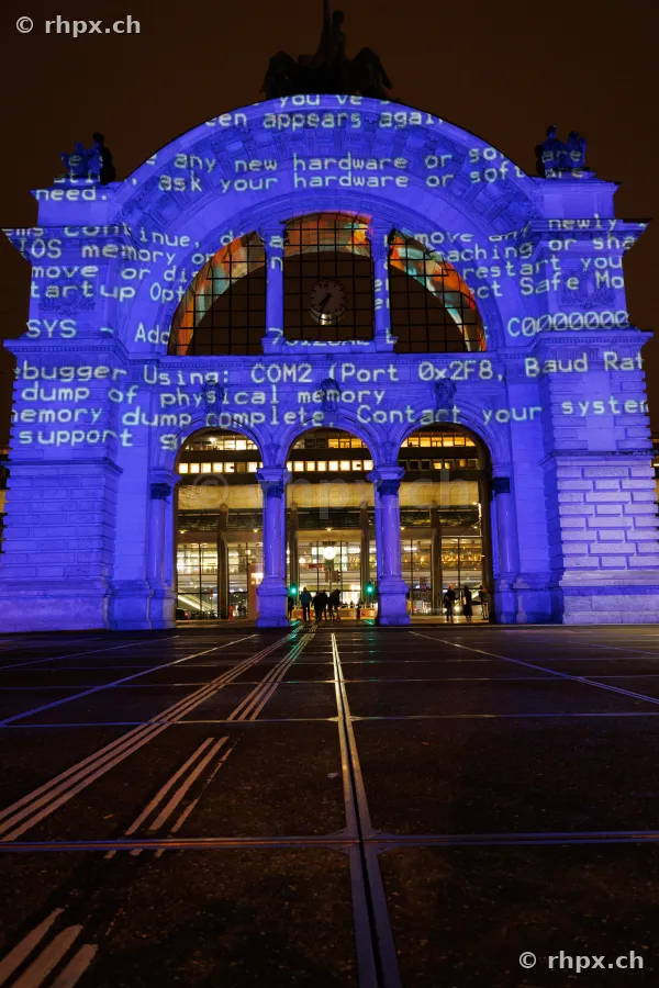 Portal des Bahnhofs Luzern mit blauer Projektion von Computercode beim Lilu Lichtfestival 2024