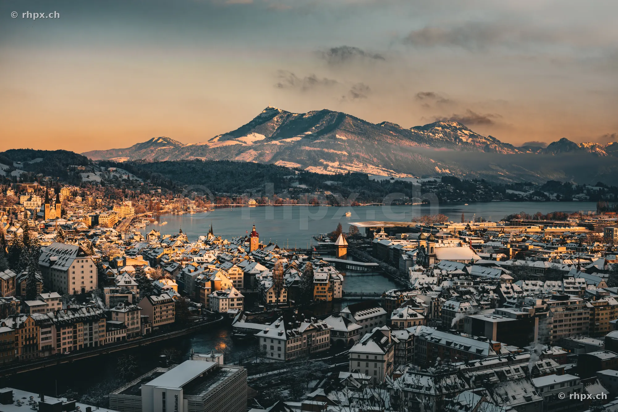 Aerial view of the snow-covered city of Lucerne, Lake Lucerne and the Rigi massif in the background