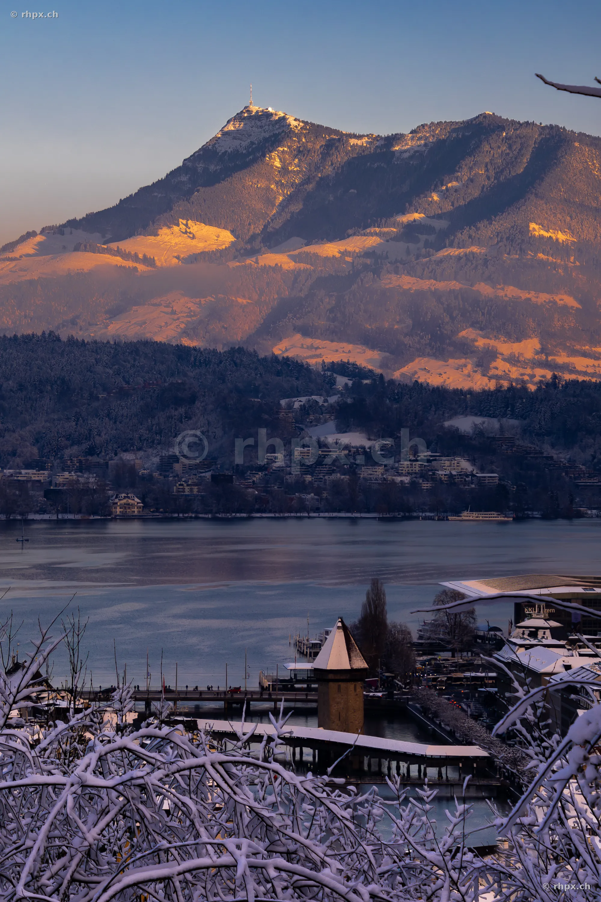 View of the snow-covered Mount Pilatus above Lake Lucerne and the city of Lucerne in the evening light