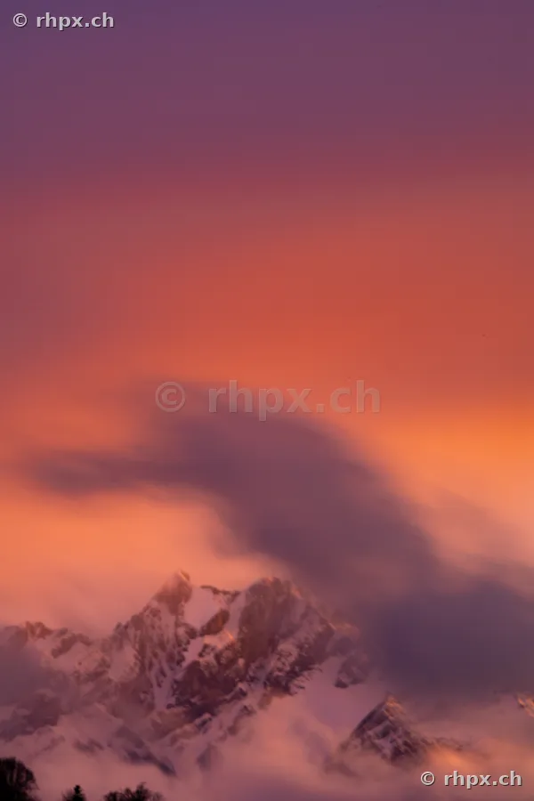 Der schneebedeckte Pilatus in warmem Abendlicht mit ziehenden Wolken
