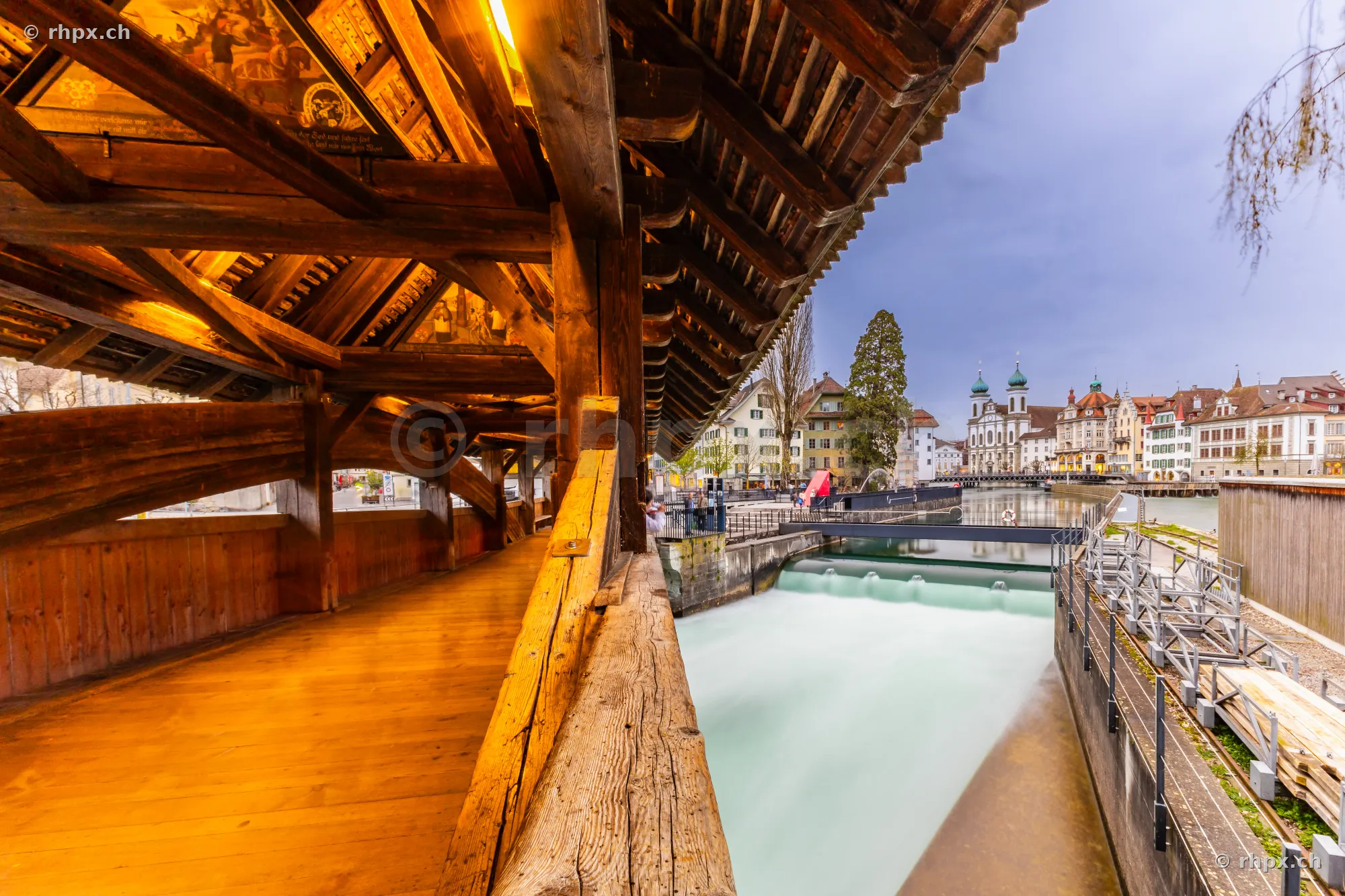 View from the wooden interior of the Spreuer Bridge in Lucerne towards the Reuss river and the old town.