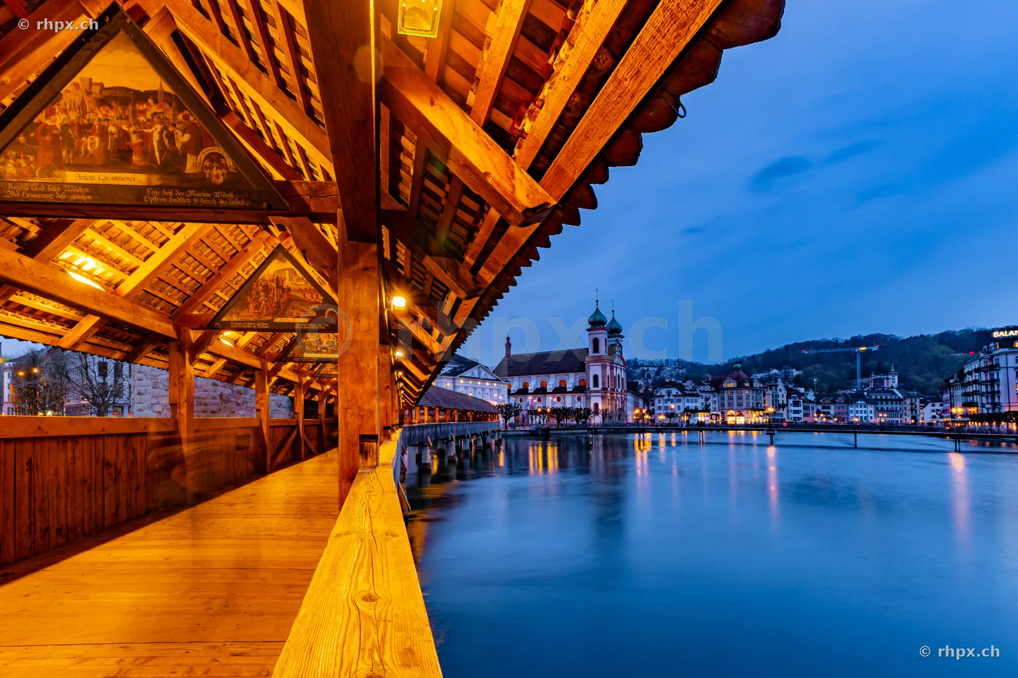 View through the interior of the Chapel Bridge in Lucerne at dusk