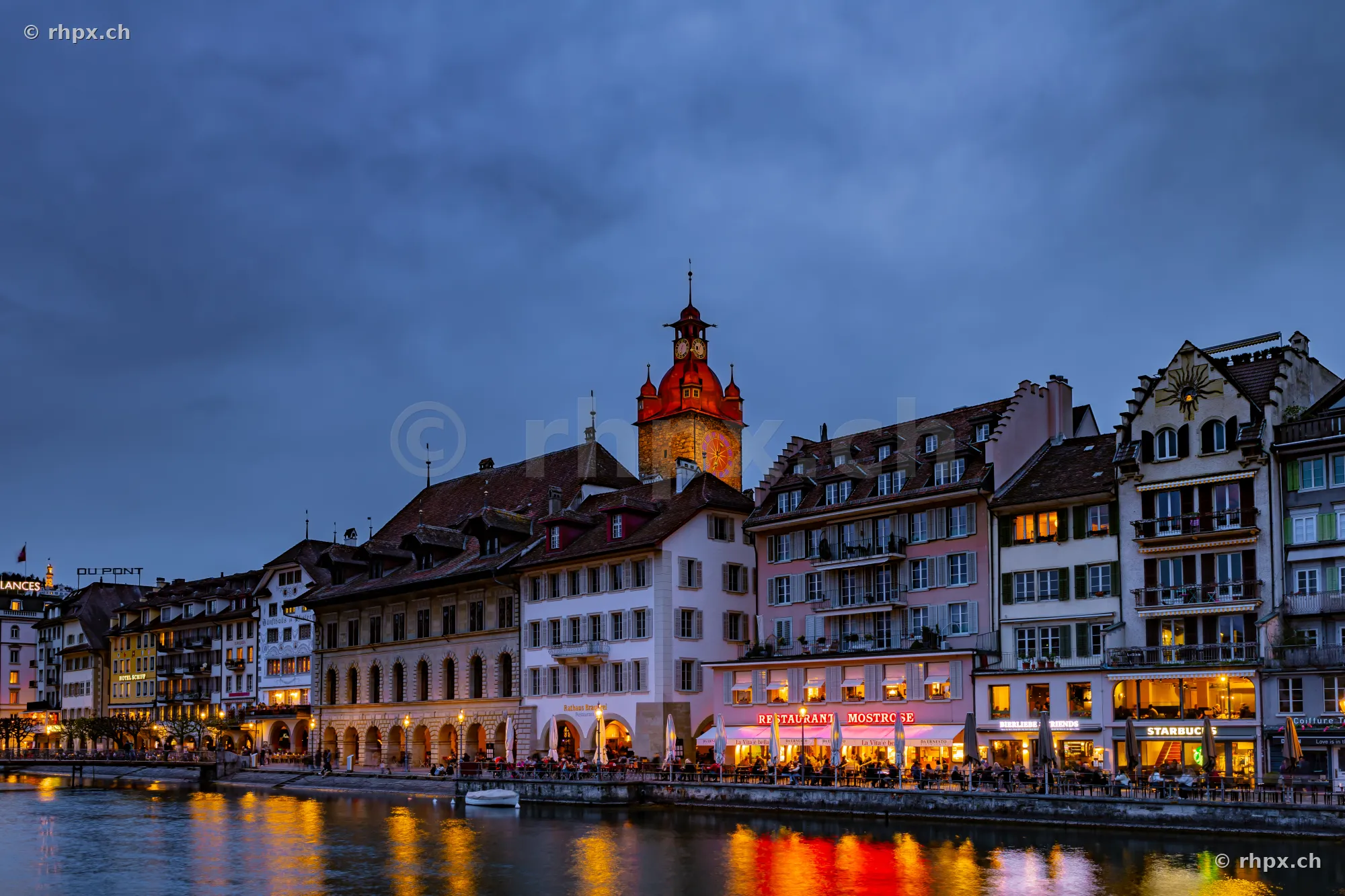The illuminated old town of Lucerne along the Reuss river at twilight