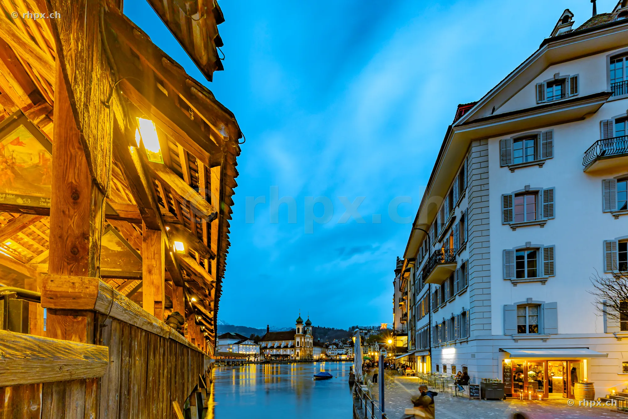 View from the Chapel Bridge in Lucerne towards the Jesuit Church on the Reuss river at dusk