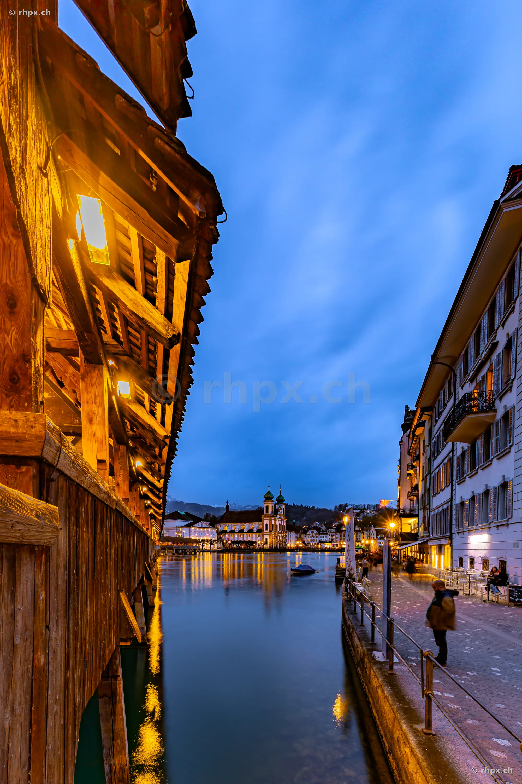 View from the Chapel Bridge over the Reuss river towards the Jesuit Church in Lucerne at dusk