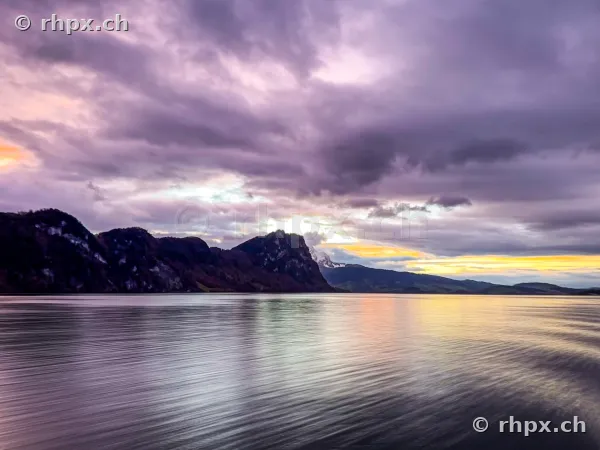 Blick über den Vierwaldstättersee mit Bürgenstock-Felsen unter dramatisch bewölktem Abendhimmel
