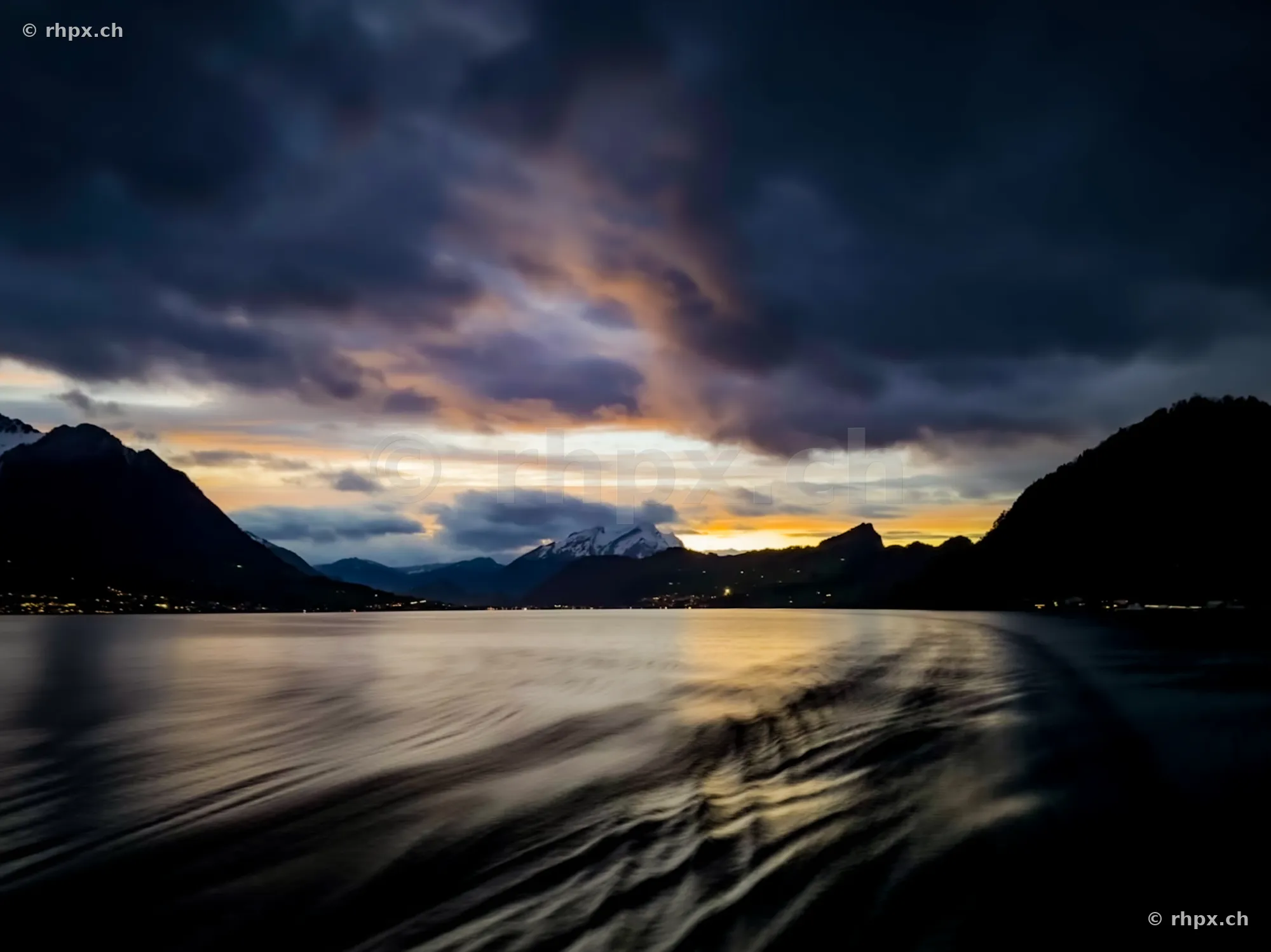 View across the wavy Lake Lucerne at dusk with mountains in the background