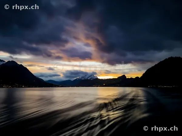 Blick über den bewegten Vierwaldstättersee gegen Abend mit Bergen im Hintergrund