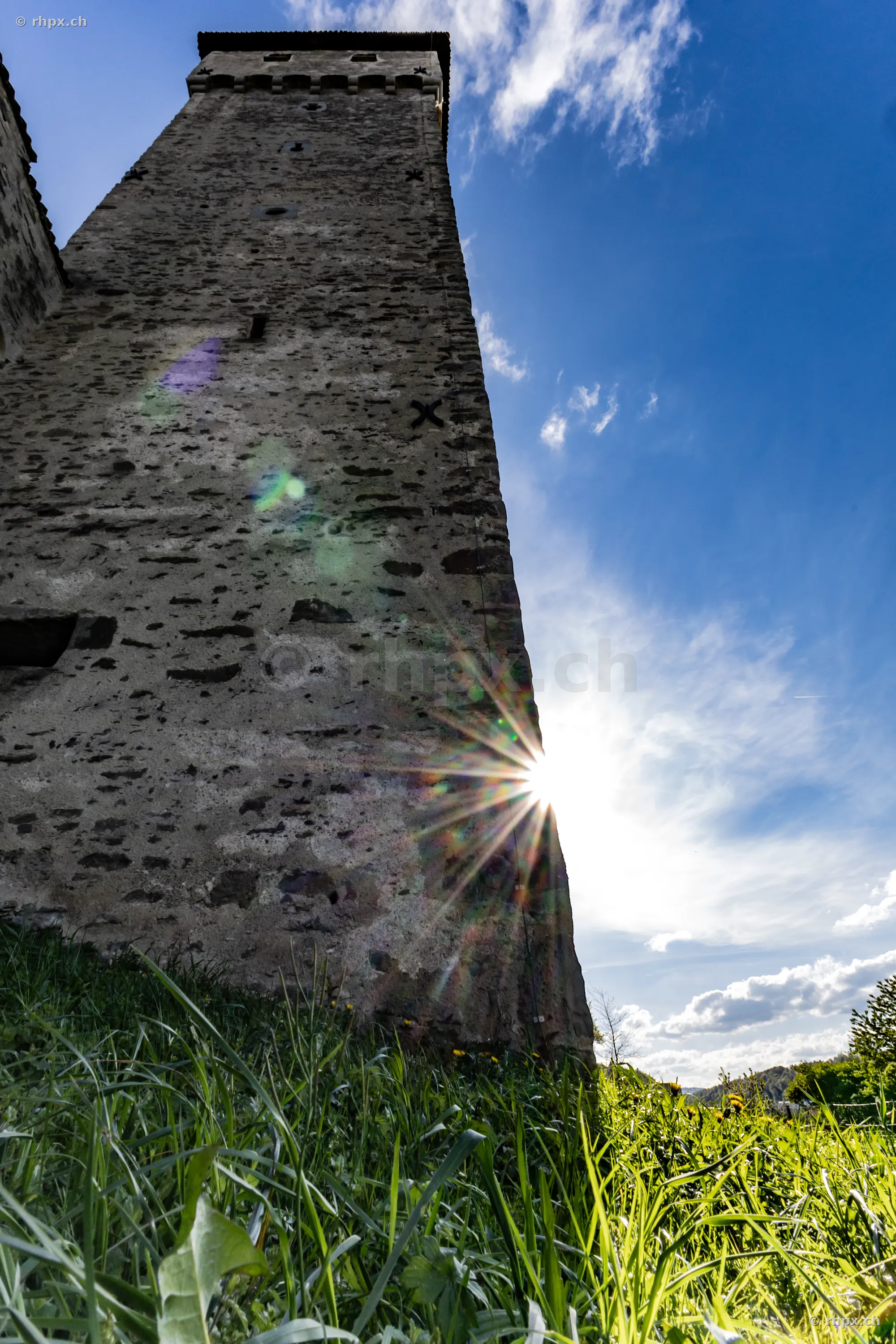 Low angle view of an old defensive tower of the Musegg Wall in Lucerne with strong backlight