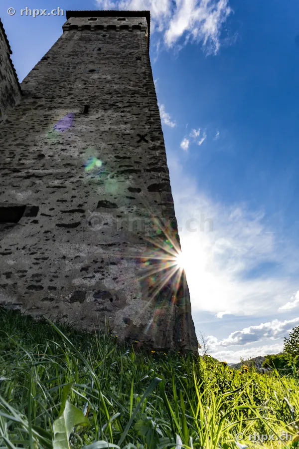 Blick von unten auf einen alten Wehrturm der Museggmauer in Luzern bei starkem Gegenlicht