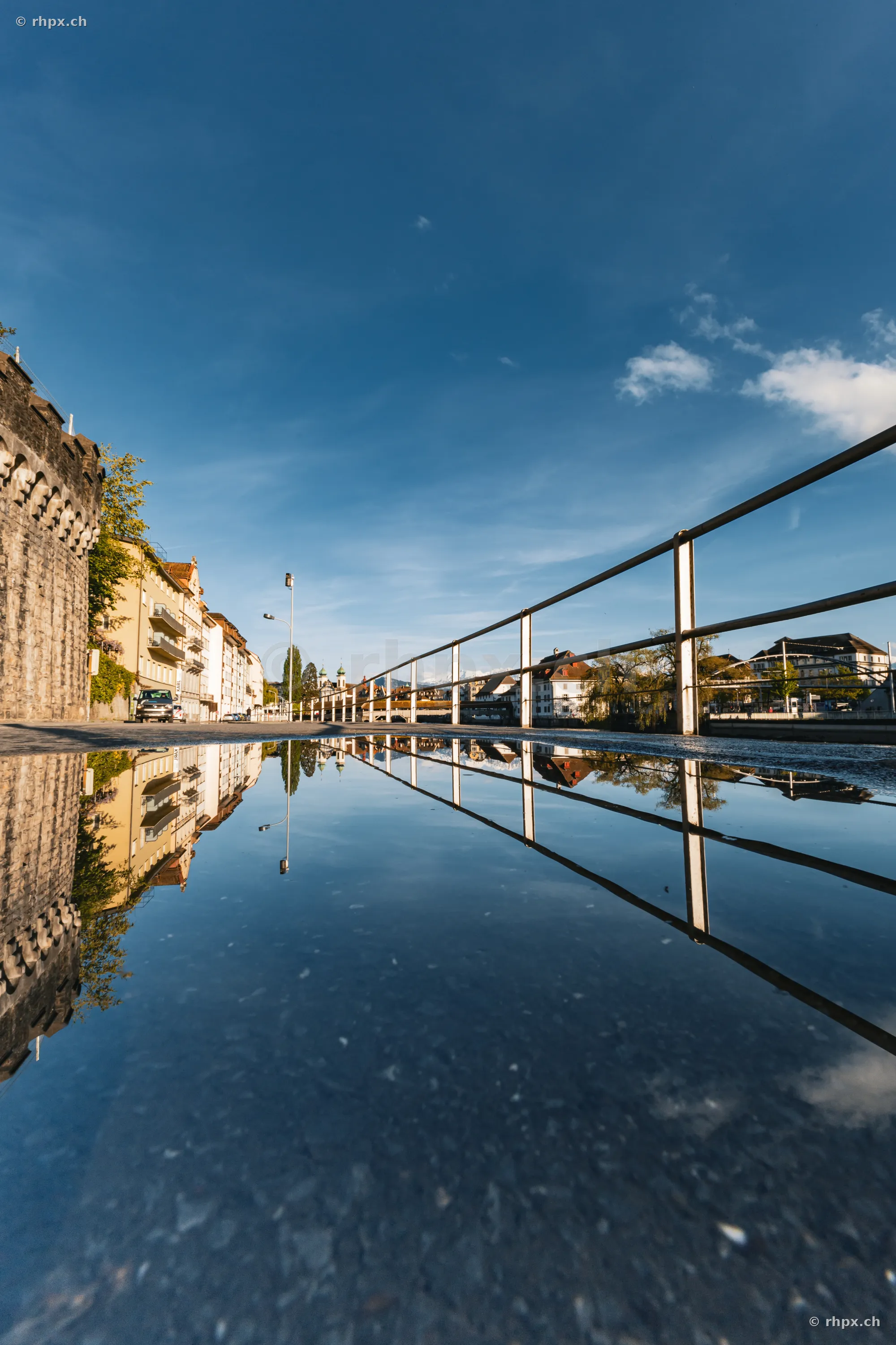 Reflection of the Musegg Wall and the city of Lucerne in a puddle on the ground