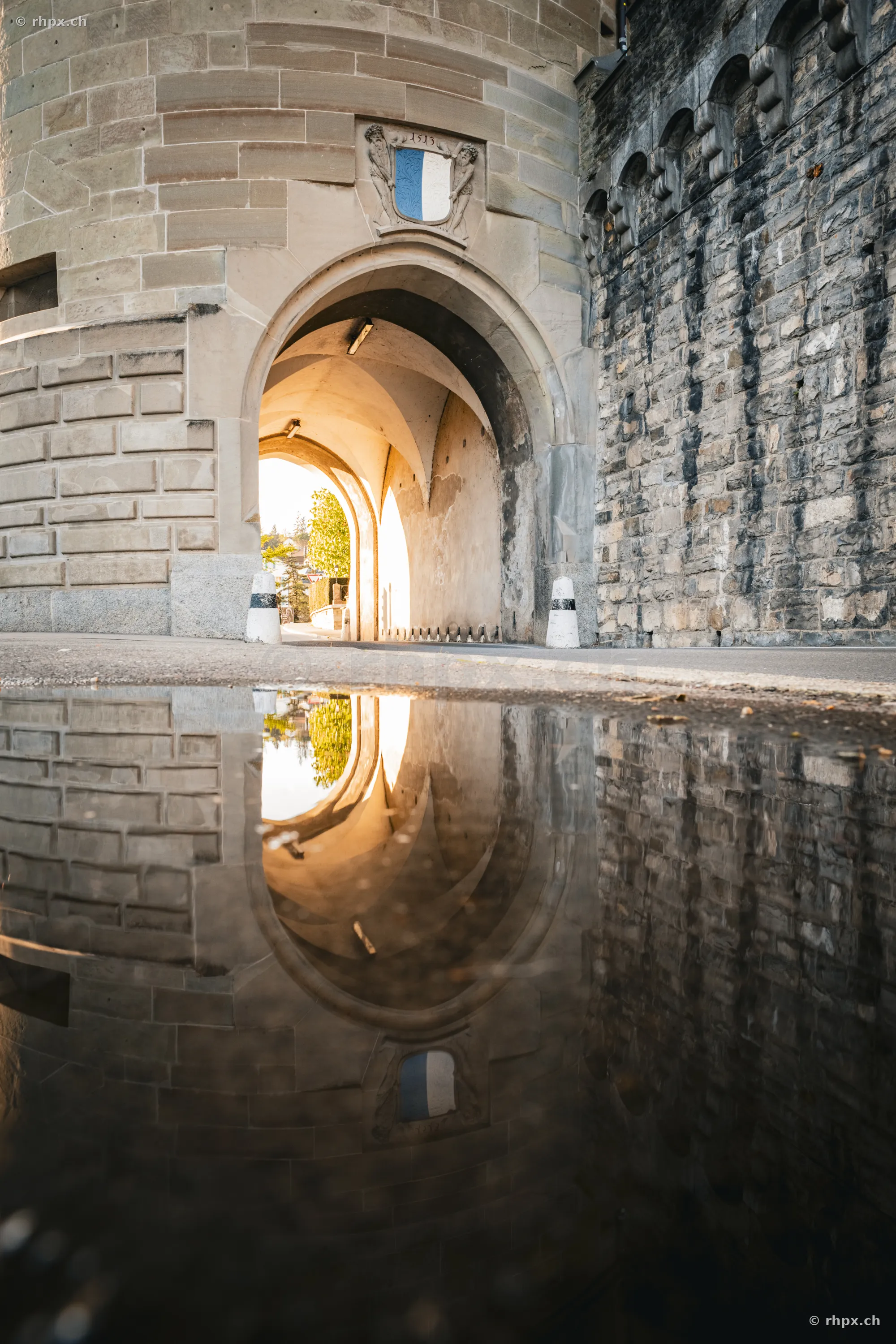 The watchtower of the Museggmauer in Lucerne is reflected in a puddle on the street