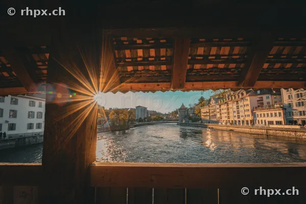 Blick durch das Gebälk der Kapellbrücke über die Reuss in Luzern mit einfallendem Sonnenlicht