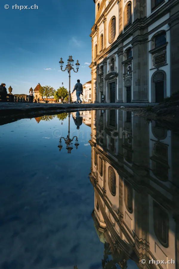 Jesuit Church in Lucerne reflected in a puddle on the ground