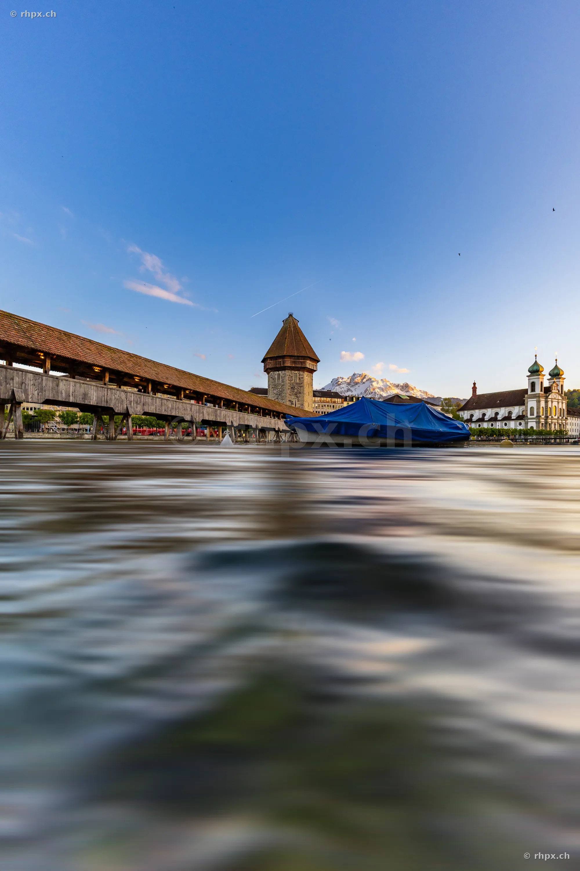 Chapel Bridge and Water Tower in Lucerne at dusk with motion-blurred water