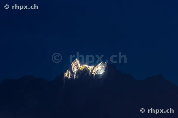 Beleuchtete Gipfelformation des Pilatus vor dunklem Nachthimmel
