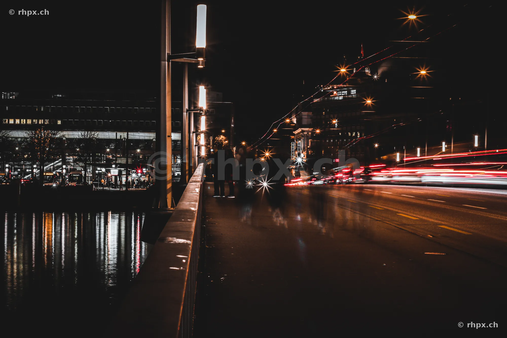 Seebrücke in Lucerne at night with passing vehicles and light trails