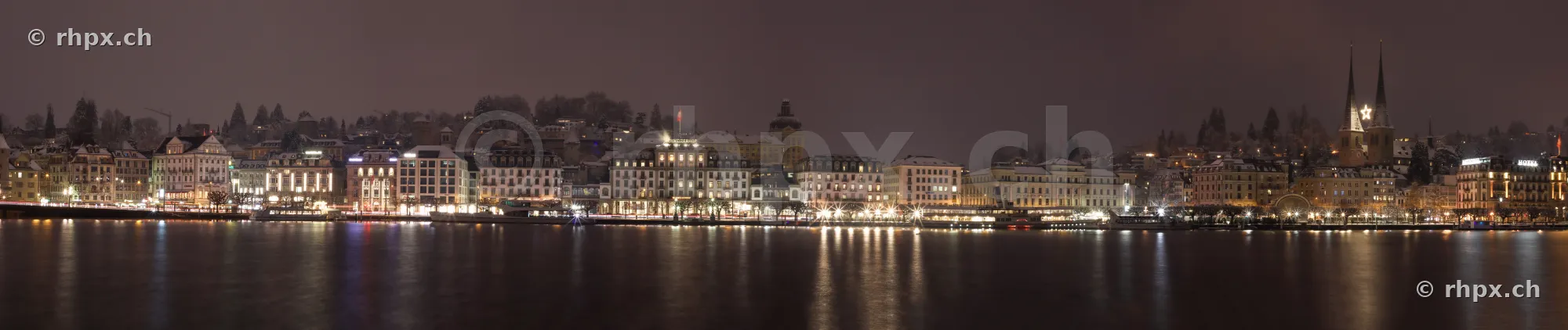 Panoramic view of the illuminated waterfront of Lucerne at night