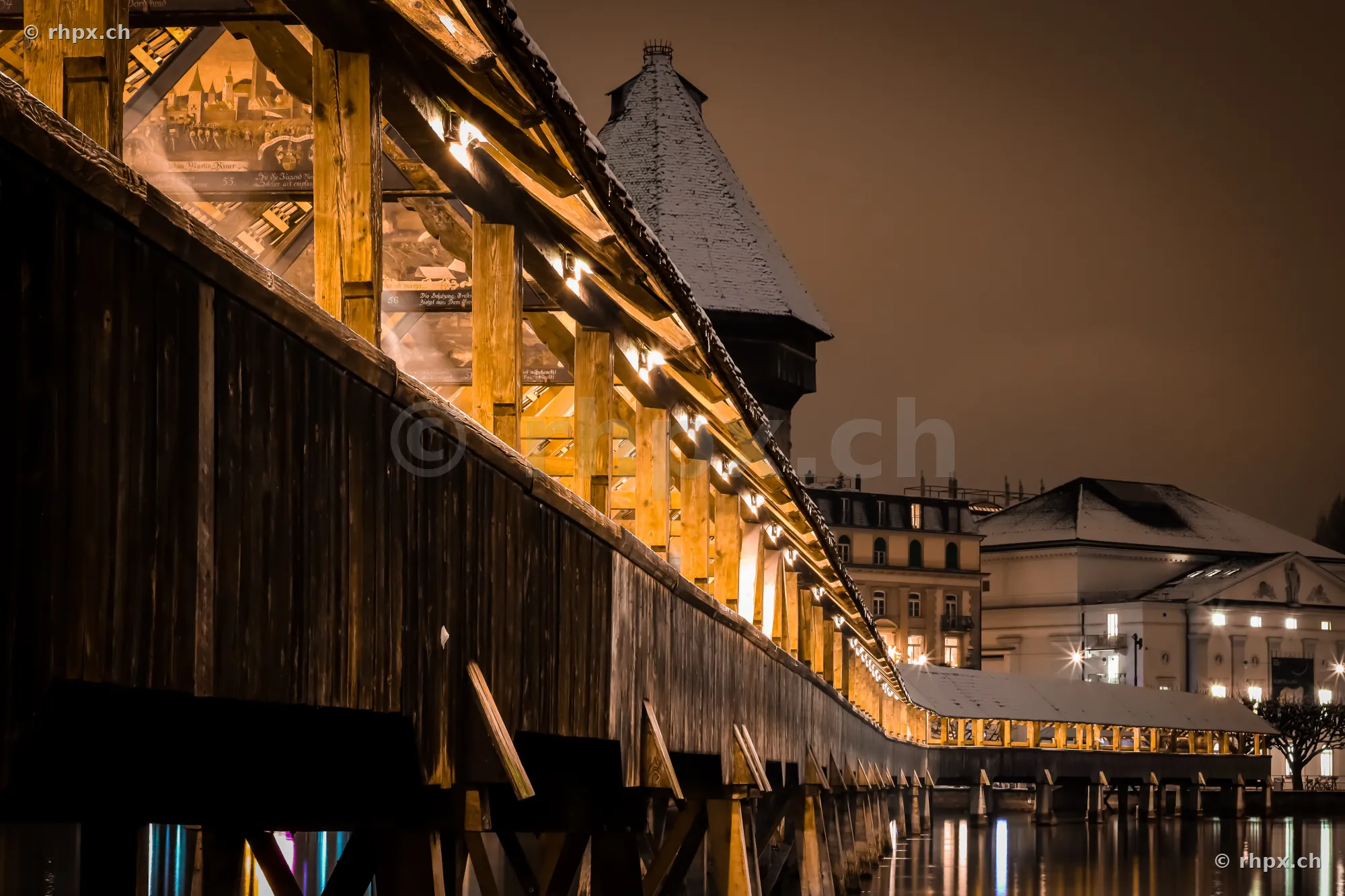 Chapel Bridge in Lucerne at night with snow on the roof