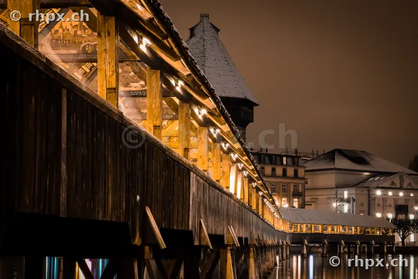 Kapellbrücke in Luzern bei Nacht mit Schnee auf dem Dach