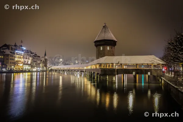 Kapellbrücke und Wasserturm in Luzern in einer verschneiten Winternacht