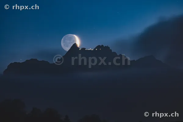 Mondsichel am Abendhimmel direkt über dem Gipfelgrat des Pilatus bei Luzern.