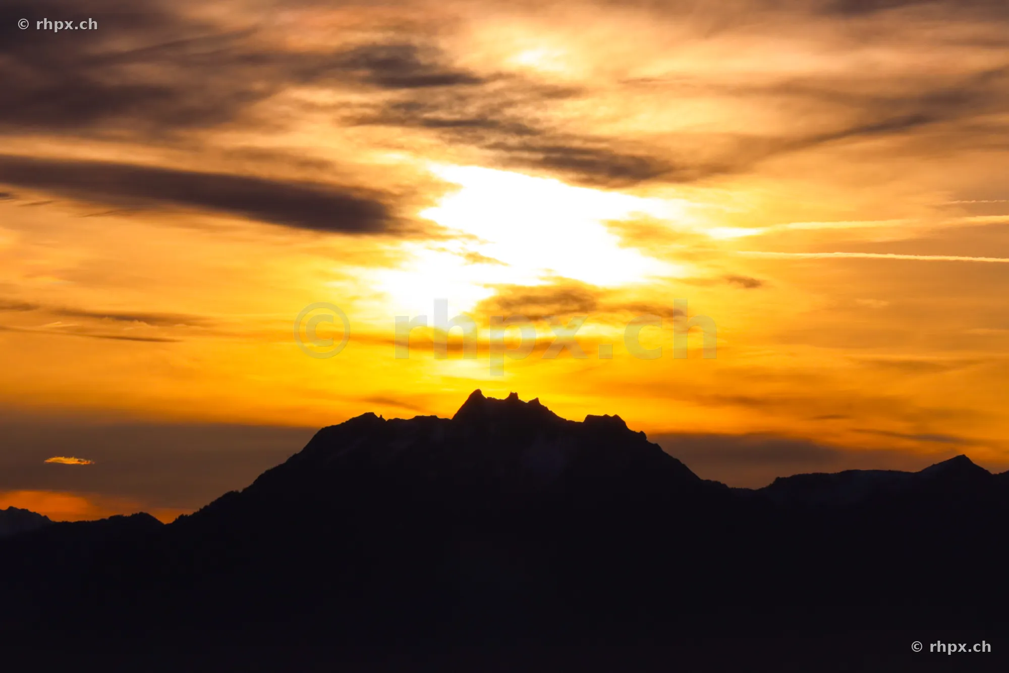 Silhouette of Mount Pilatus against a glowing evening sky