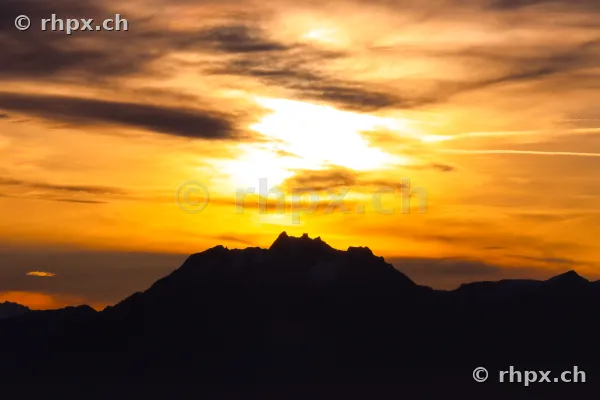 Scherenschnitt-Silhouette des Berges Pilatus vor einem intensiv leuchtenden Abendhimmel