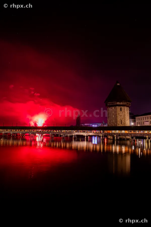 Rotes Feuerwerk über der nächtlichen Kapellbrücke am Vierwaldstättersee in Luzern