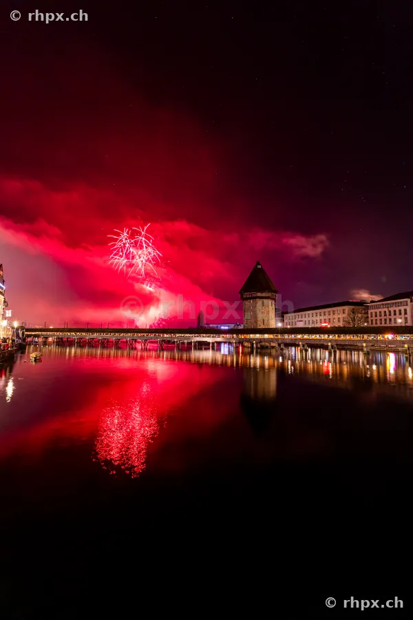 Chapel Bridge in Lucerne with New Year's fireworks in the night sky