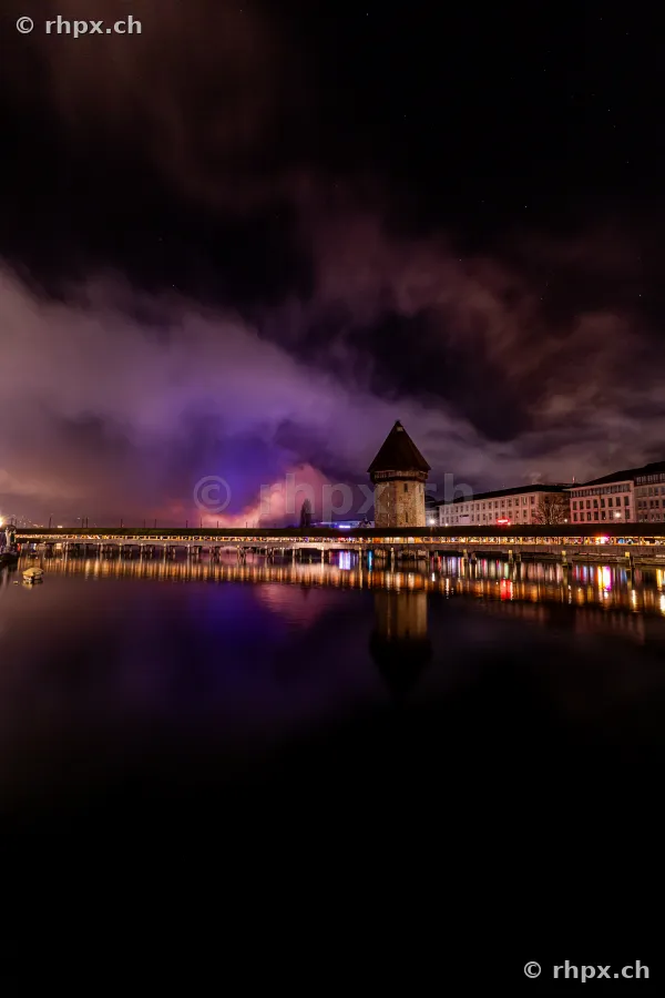 Night view of the illuminated Chapel Bridge in Lucerne during New Year fireworks on January 1, 2025