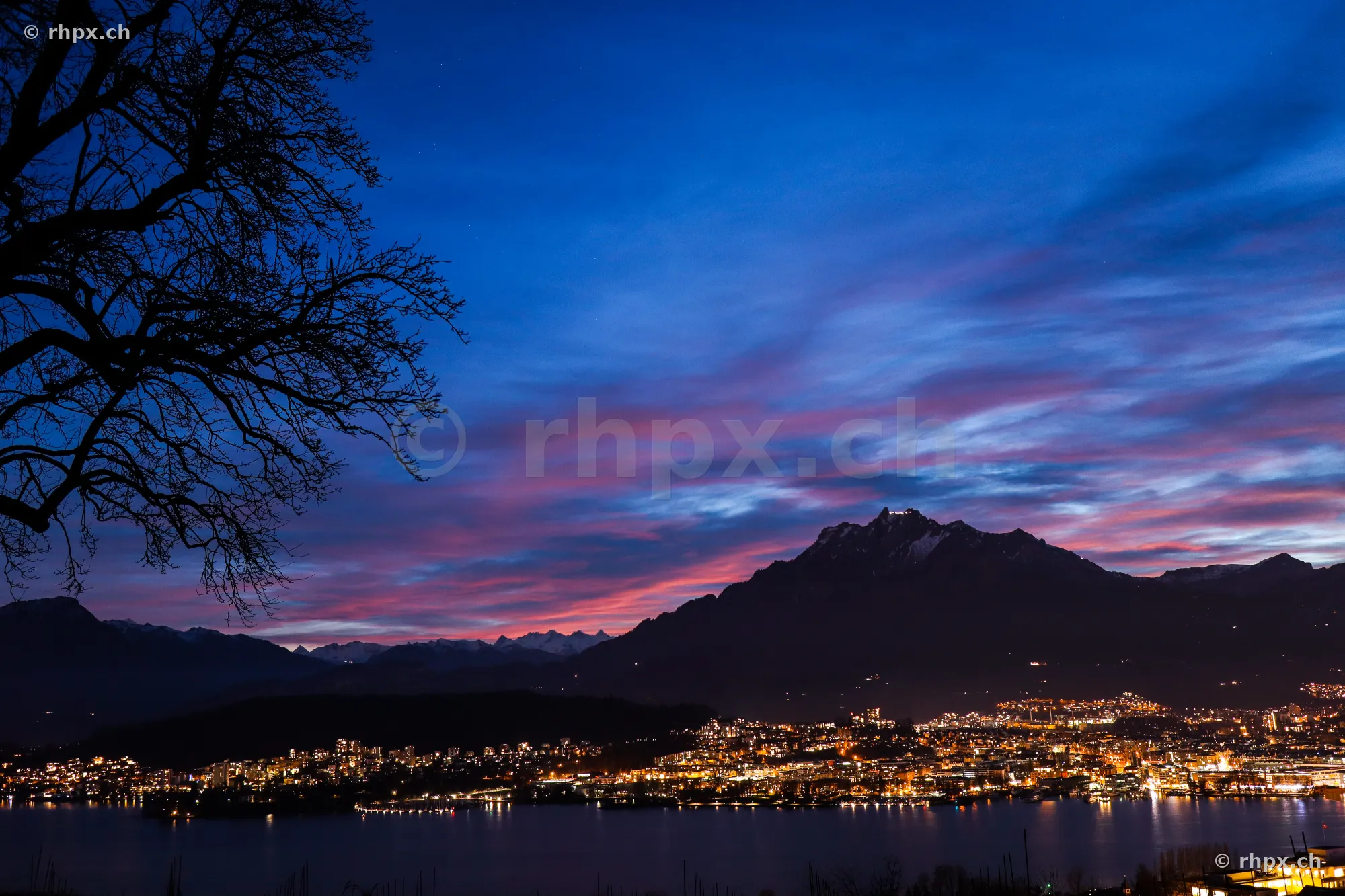 View of Lucerne and Mount Pilatus at dusk with city lights