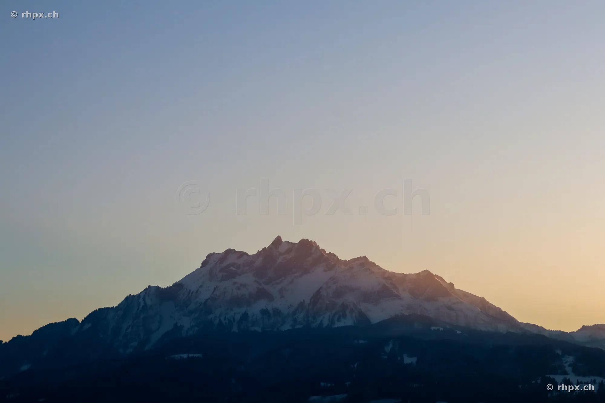 View of the snow-covered peak of Mount Pilatus at sunset