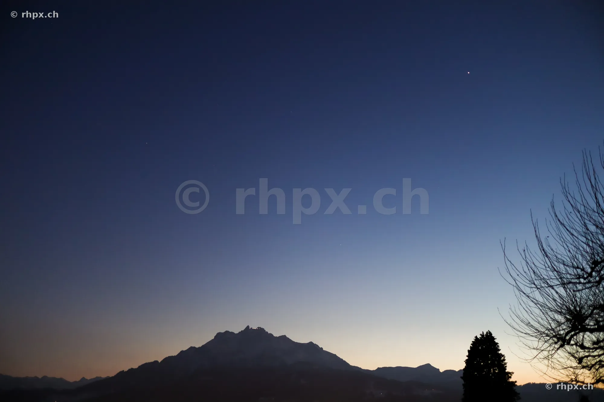 Silhouettes of Mount Pilatus during twilight in a clear sky.