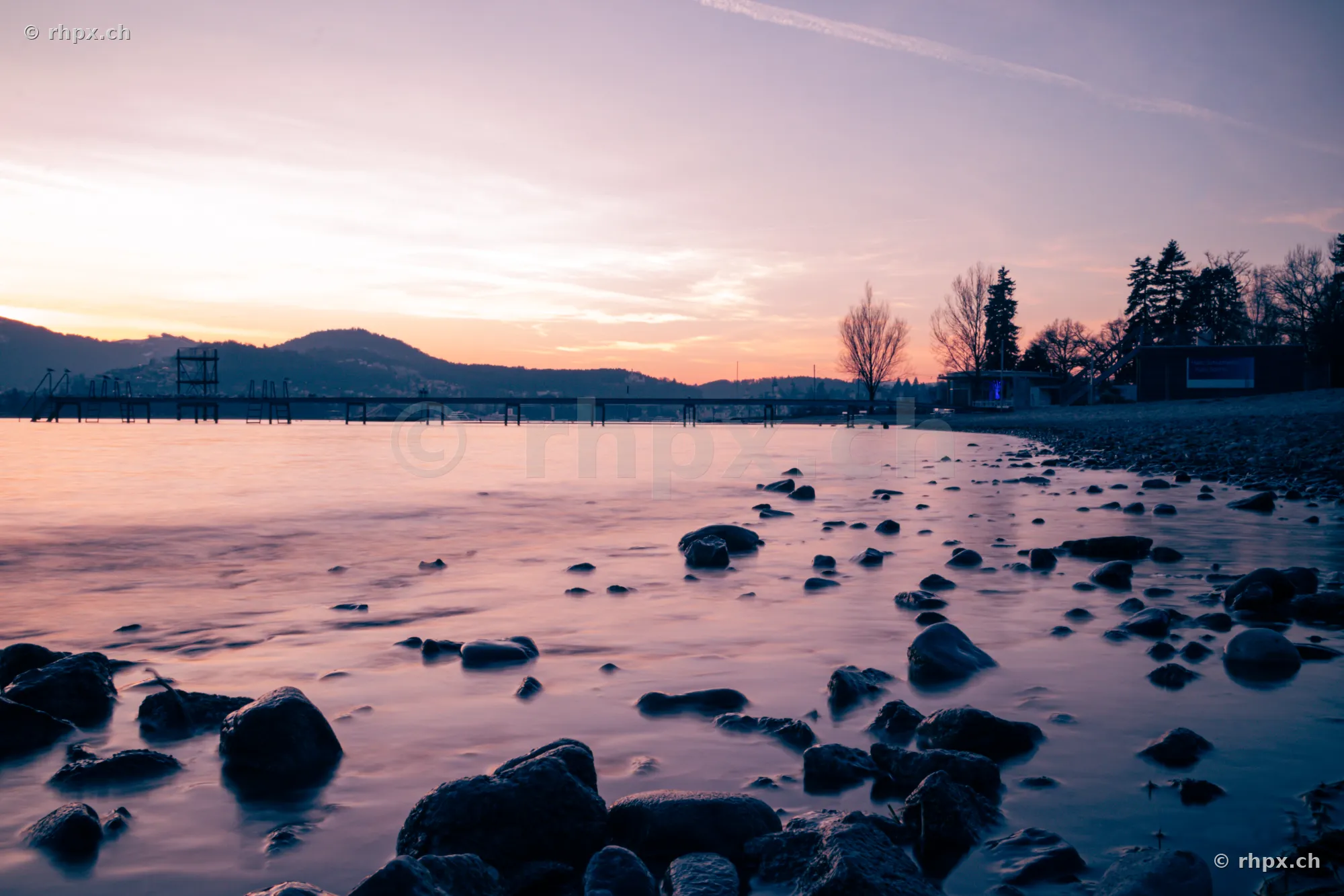 Stones in the shallow water at the shore of Lake Lucerne at sunset