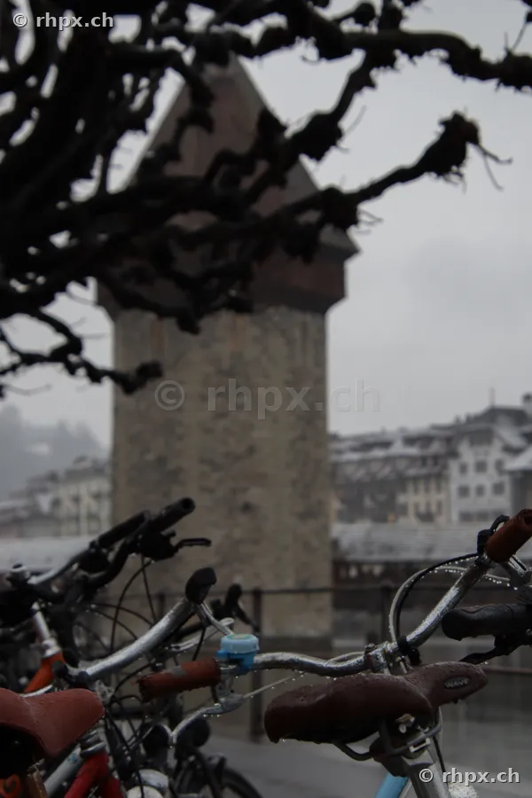 Der Wasserturm in Luzern hinter Fahrradlenkern bei regnerischem Wetter