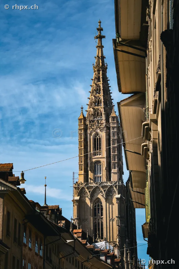 Blick auf den Turm des Berner Münsters aus einer engen Gasse der Berner Altstadt