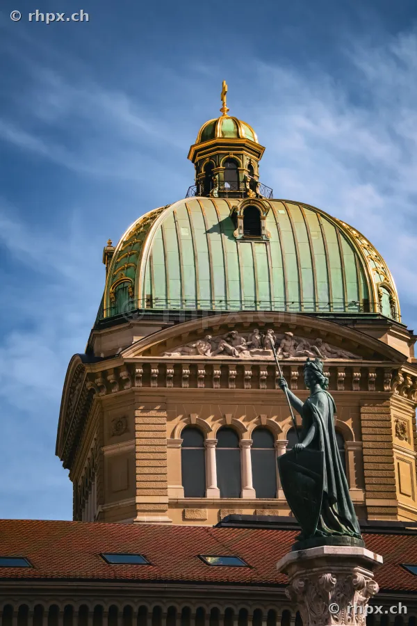 Bundeshaus Kuppel und Statue in Bern vor blauem Himmel