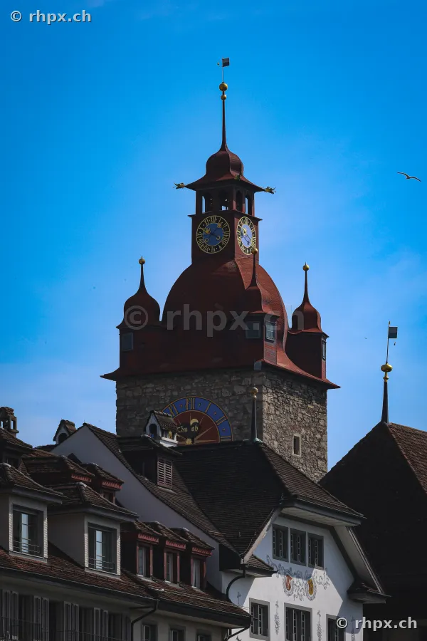 Blick auf den historischen Zytturm mit Uhrwerk vor blauem Himmel in Luzern