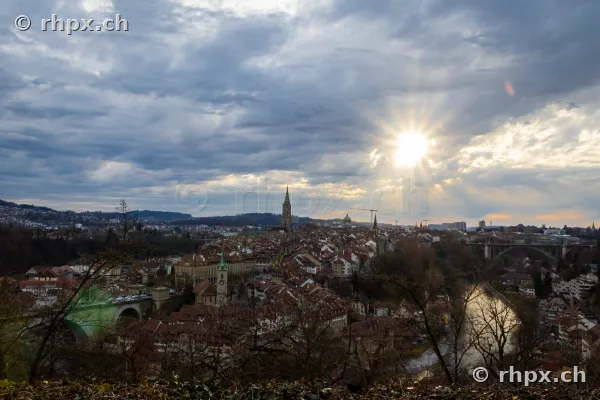 Panoramablick auf die Berner Altstadt mit Aare und Kirchenschiff bei bewölktem Himmel
